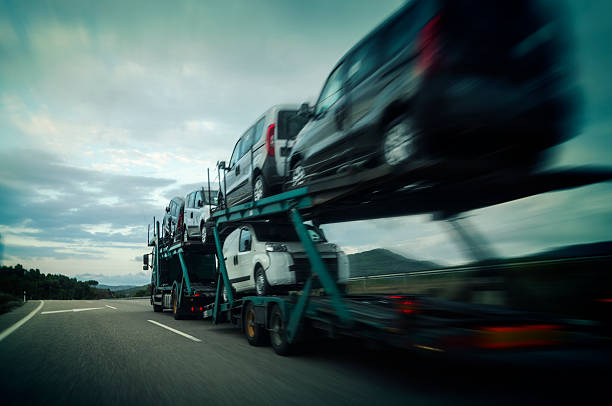 A car carrier truck transports multiple vehicles along a highway at dusk, with motion blur emphasizing its speed—exemplifying the efficiency of Car Transport Clearwater, FL and reliable car shipping services in the area.